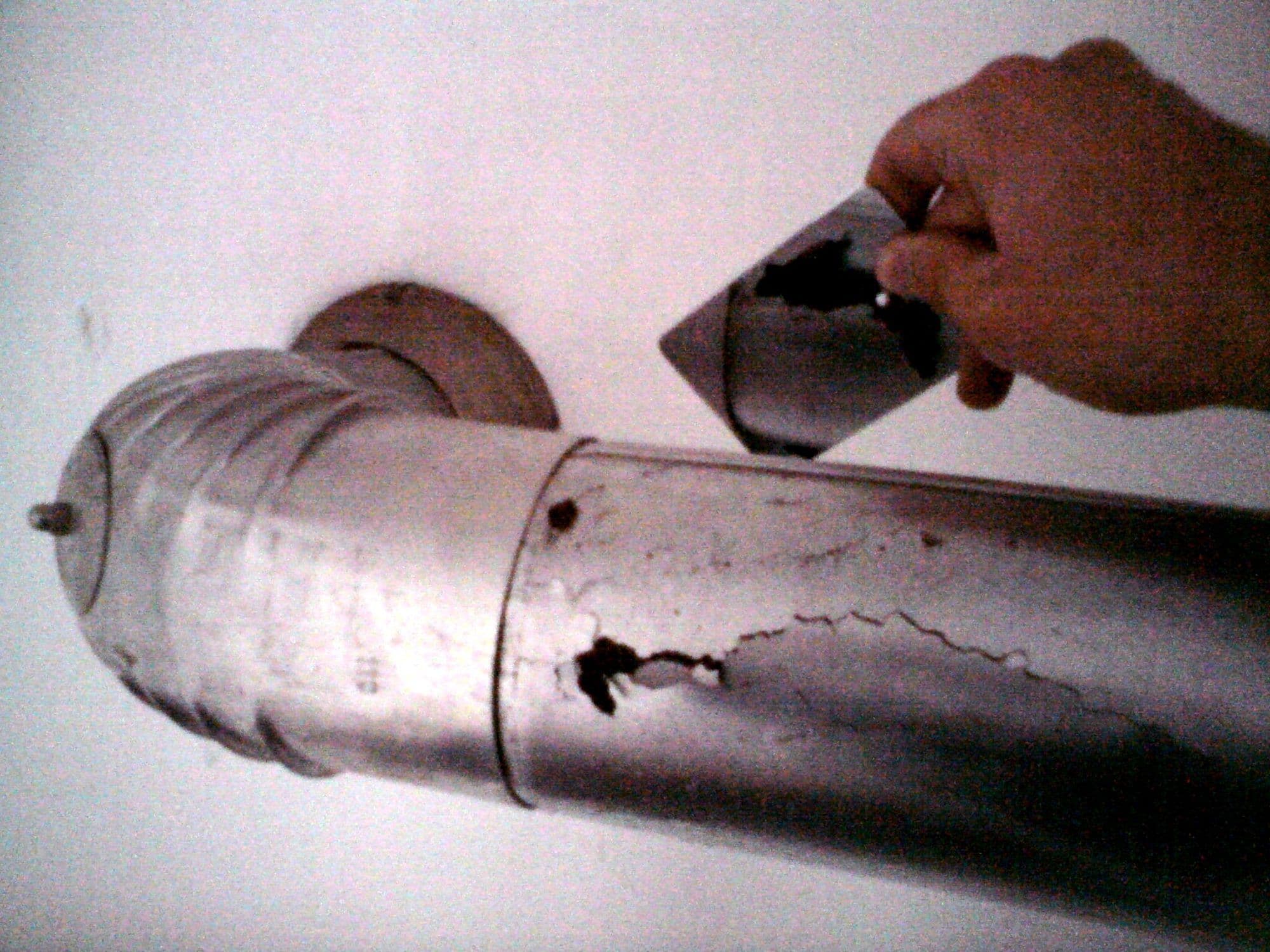 Hand an einem Abgasrohr aus Metall